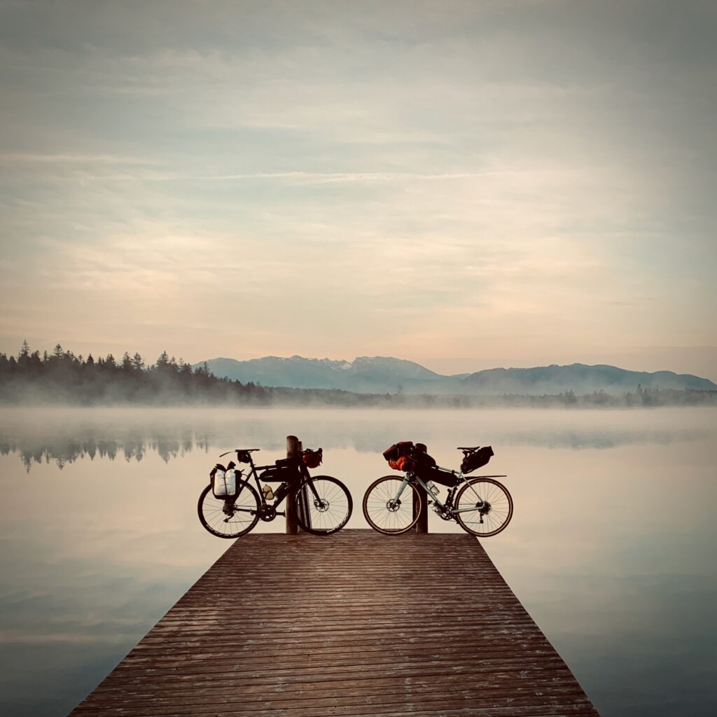 Zwei Gravelbikes am Kirchsee vor dem Kloster Reutberg